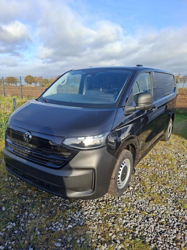 Volkswagen T7 Kastenwagen Basis 2.0 TDI 150PS AUTOMATIK, SCHWARZ-MET, HECKFLÜGELTÜREN, 2-Zonen-Klimautomatik, M-Lederlenkrad, Anhängerkupplung, Parksensoren vorn/hinten, Rückfahrkamera, Frontscheibe beheizbar, Ganzjahresreifen, Sitzpaket 46 (inkl. Sitzheizung), Reserverad, 70 Liter 
