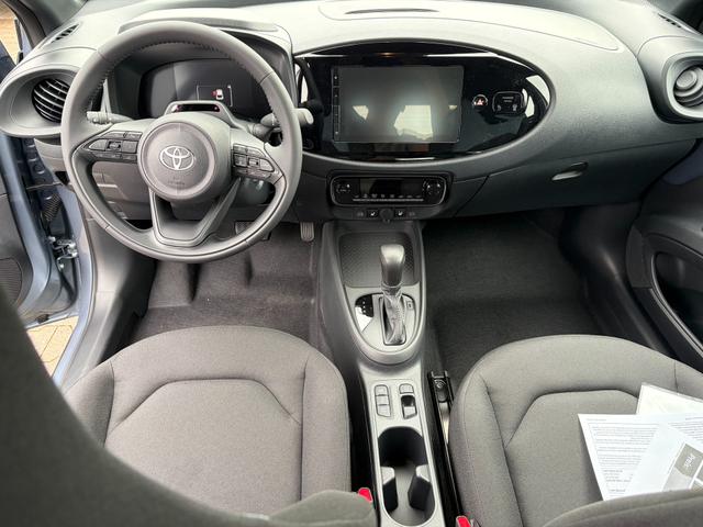 Toyota Aygo X Play 1.5 Hybrid 115PS CVT/AUTOMATIK, Celestite Grey Metallic , 3 Jahre Garantie, 17" Alufelgen, Sitzheizung, R&uuml;ckfahrkamera, Klimaautomatik, Audiosystem 9" + Smartphone-Integration, Lederlenkrad, ACC, ZV mit Fernbedienung 
