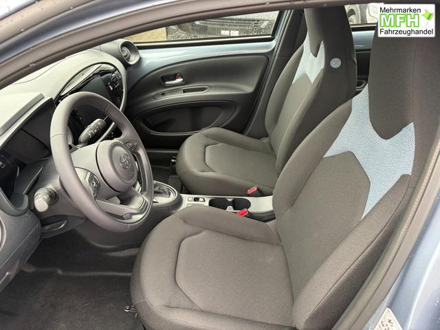 Toyota Aygo X Play 1.5 Hybrid 115PS CVT/AUTOMATIK, Celestite Grey Metallic , 3 Jahre Garantie, 17" Alufelgen, Sitzheizung, R&uuml;ckfahrkamera, Klimaautomatik, Audiosystem 9" + Smartphone-Integration, Lederlenkrad, ACC, ZV mit Fernbedienung 