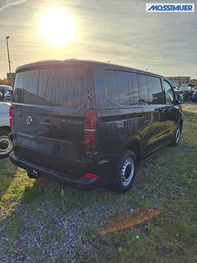 Volkswagen T7 Kastenwagen Basis 2.0 TDI 150PS AUTOMATIK, SCHWARZ-MET, HECKFLÜGELTÜREN, 2-Zonen-Klimautomatik, M-Lederlenkrad, Anhängerkupplung, Parksensoren vorn/hinten, Rückfahrkamera, Frontscheibe beheizbar, Ganzjahresreifen, Sitzpaket 46 (inkl. Sitzheizung), Reserverad, 70 Liter 