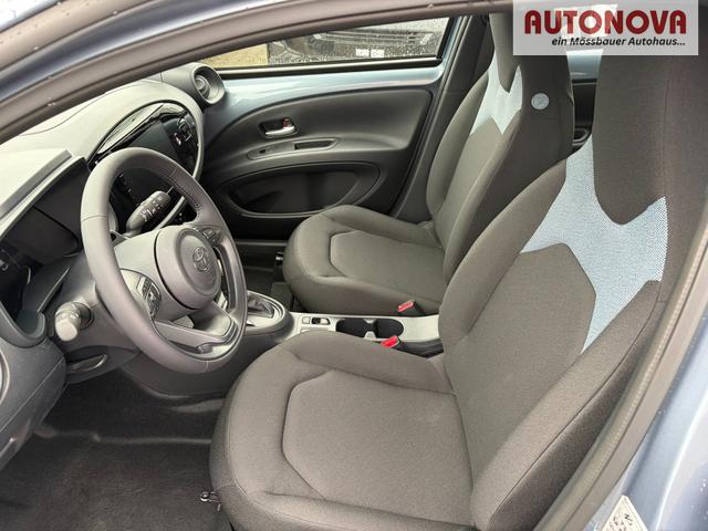 Toyota Aygo X Play 1.5 Hybrid 115PS CVT/AUTOMATIK, Celestite Grey Metallic , 3 Jahre Garantie, 17" Alufelgen, Sitzheizung, R&uuml;ckfahrkamera, Klimaautomatik, Audiosystem 9" + Smartphone-Integration, Lederlenkrad, ACC, ZV mit Fernbedienung 