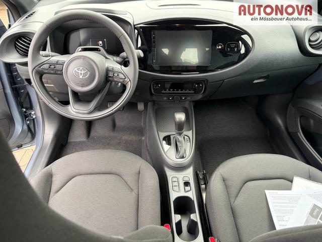 Toyota Aygo X Play 1.5 Hybrid 115PS CVT/AUTOMATIK, Celestite Grey Metallic , 3 Jahre Garantie, 17" Alufelgen, Sitzheizung, R&uuml;ckfahrkamera, Klimaautomatik, Audiosystem 9" + Smartphone-Integration, Lederlenkrad, ACC, ZV mit Fernbedienung 